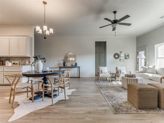 11700 SW 15th Ter, Yukon, OK 73099 - dining space featuring crown molding, a chandelier, a ceiling fan, and light wood-style flooring