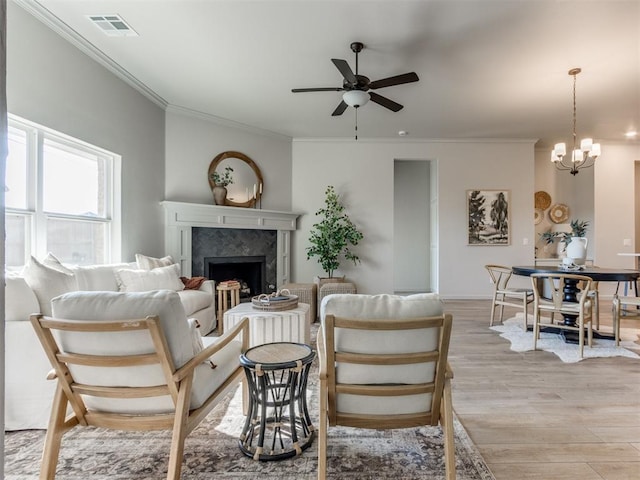 11700 SW 15th Ter, Yukon, OK 73099 - living area with a ceiling fan, ornamental molding, light wood-style flooring, a premium fireplace, and a chandelier