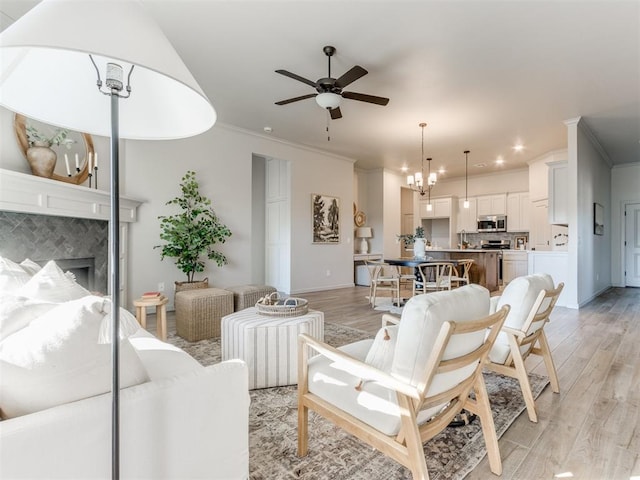 11700 SW 15th Ter, Yukon, OK 73099 - living area with a ceiling fan, light wood finished floors, ornamental molding, a chandelier, and a tiled fireplace