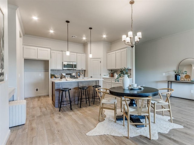 11700 SW 15th Ter, Yukon, OK 73099 - dining area with ornamental molding, light wood finished floors, a chandelier, and recessed lighting