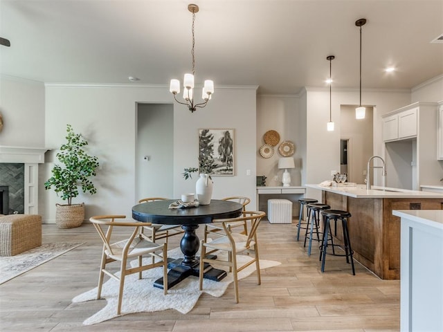 11700 SW 15th Ter, Yukon, OK 73099 - dining space featuring crown molding, light wood-style flooring, a chandelier, and a premium fireplace