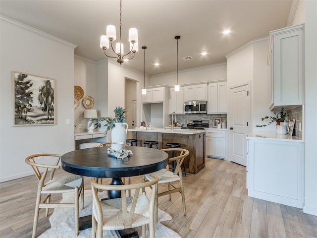 11700 SW 15th Ter, Yukon, OK 73099 - dining space featuring light wood finished floors, crown molding, a chandelier, and recessed lighting