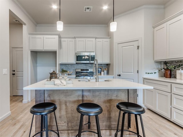 11700 SW 15th Ter, Yukon, OK 73099 - kitchen featuring appliances with stainless steel finishes, tasteful backsplash, crown molding, a kitchen bar, and light countertops