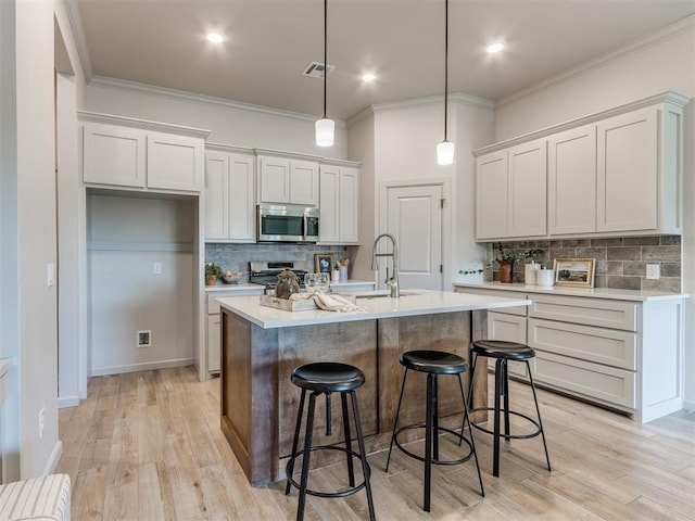 11700 SW 15th Ter, Yukon, OK 73099 - kitchen with appliances with stainless steel finishes, tasteful backsplash, light countertops, a kitchen breakfast bar, and ornamental molding