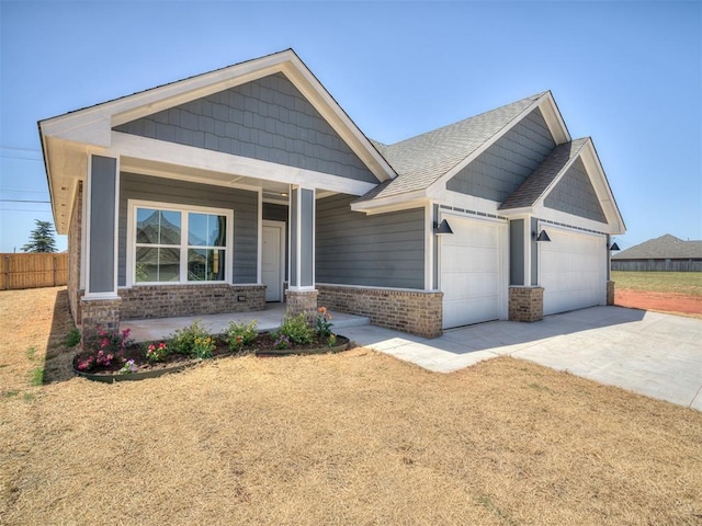 11700 SW 15th Ter, Yukon, OK 73099 - view of front of house with brick siding, a porch, an attached garage, driveway, and roof with shingles