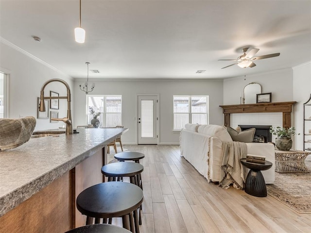 11728 SW 14th St, Yukon, OK 73099 - living room featuring crown molding, light wood-style flooring, healthy amount of natural light, ceiling fan, and a tile fireplace