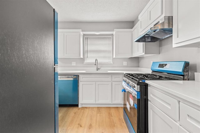 4800 SE 45th St, Oklahoma City, OK 73135 - kitchen featuring stainless steel appliances, under cabinet range hood, light wood-style flooring, white cabinets, and a textured ceiling