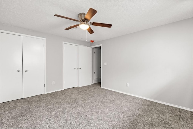 4800 SE 45th St, Oklahoma City, OK 73135 - unfurnished bedroom featuring multiple closets, carpet, ceiling fan, and a textured ceiling
