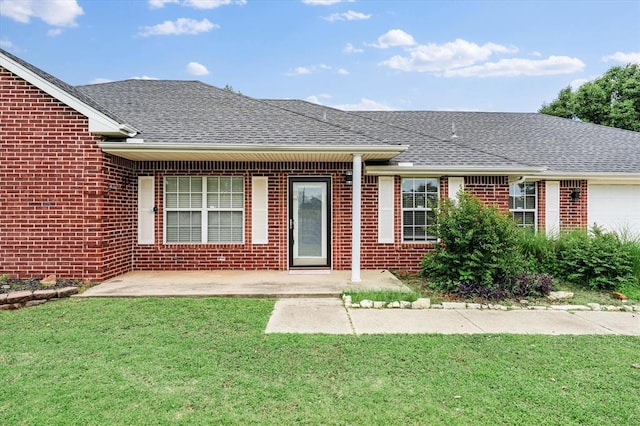 910796 S 3350th Rd, Wellston, OK 74881 - ranch-style home with a front lawn, roof with shingles, an attached garage, brick siding, and a patio area
