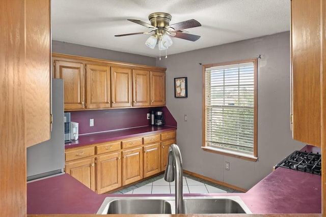 910796 S 3350th Rd, Wellston, OK 74881 - kitchen with ceiling fan, dark countertops, and brown cabinetry