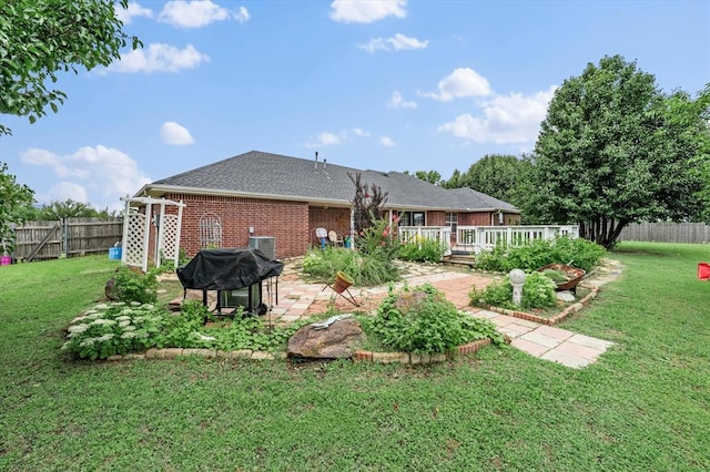 910796 S 3350th Rd, Wellston, OK 74881 - rear view of house featuring a fenced backyard, brick siding, a wooden deck, and a patio