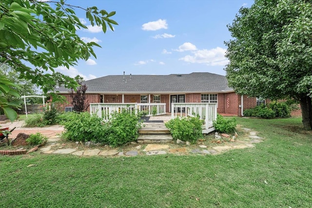 910796 S 3350th Rd, Wellston, OK 74881 - rear view of property featuring brick siding, a lawn, a wooden deck, and roof with shingles