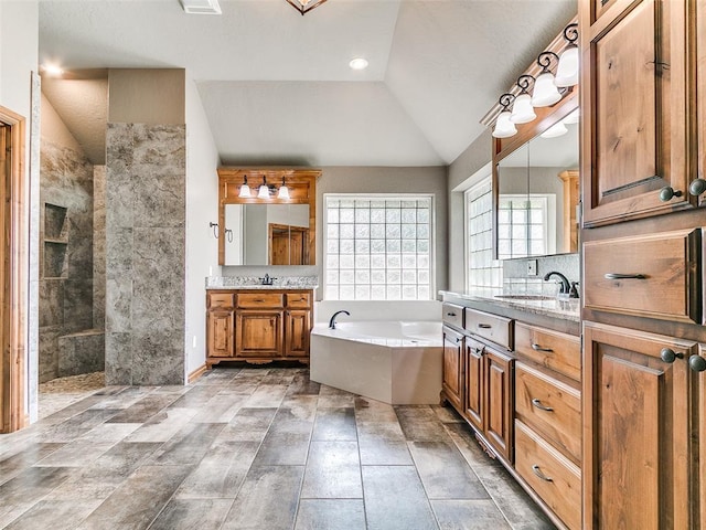 12905 S Mustang Rd, Mustang, OK 73064 - bathroom with lofted ceiling, a garden tub, two vanities, and walk in shower