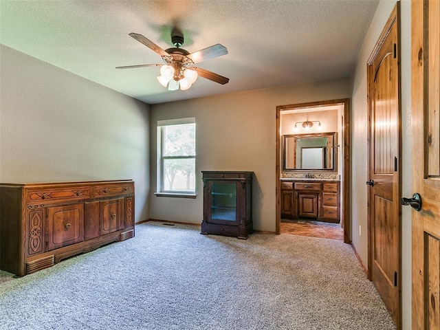 12905 S Mustang Rd, Mustang, OK 73064 - bedroom with light colored carpet, connected bathroom, a textured ceiling, and a ceiling fan