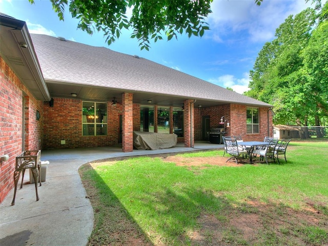 12905 S Mustang Rd, Mustang, OK 73064 - rear view of house featuring brick siding, a patio, a lawn, and a shingled roof