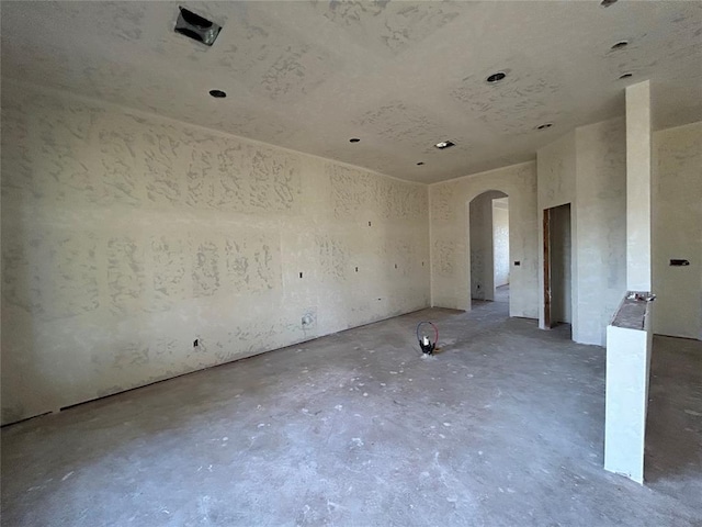 3850 E Camp Dr, Guthrie, OK 73044 - empty room with arched walkways and unfinished concrete flooring