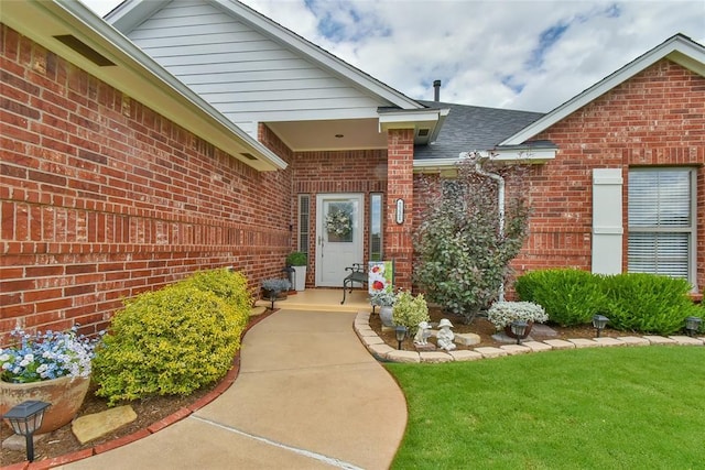 2221 NW 158th St, Edmond, OK 73013 - doorway to property featuring brick siding, a lawn, and roof with shingles