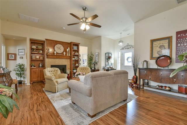 2221 NW 158th St, Edmond, OK 73013 - living room featuring a fireplace, ceiling fan, and wood finished floors