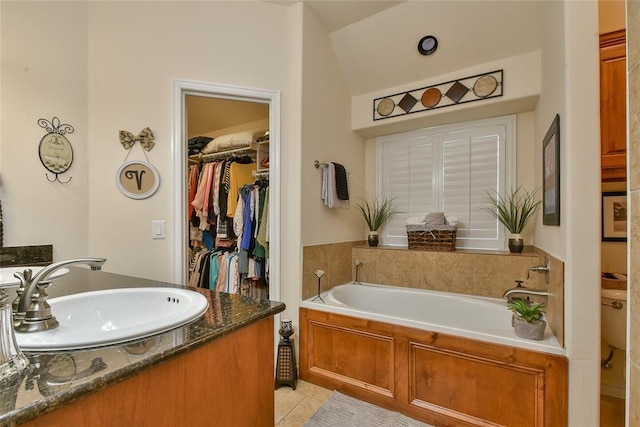2221 NW 158th St, Edmond, OK 73013 - full bath featuring a garden tub, tile patterned floors, vanity, a spacious closet, and lofted ceiling