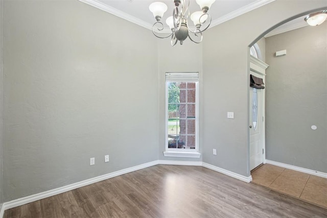 4605 Mackenzie Dr, Moore, OK 73160 - unfurnished room with arched walkways, wood finished floors, ornamental molding, and a chandelier