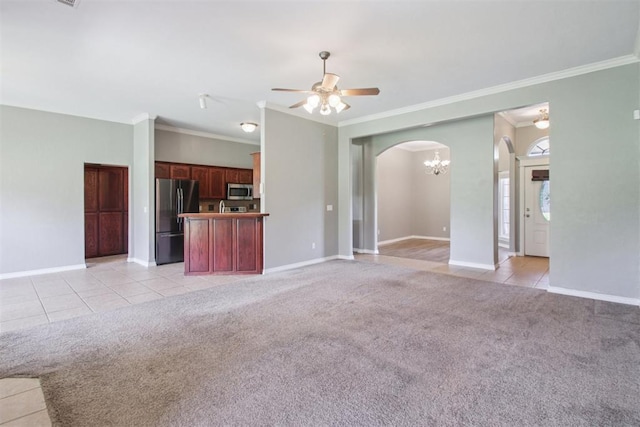 4605 Mackenzie Dr, Moore, OK 73160 - unfurnished living room featuring arched walkways, crown molding, light tile patterned floors, a ceiling fan, and light carpet