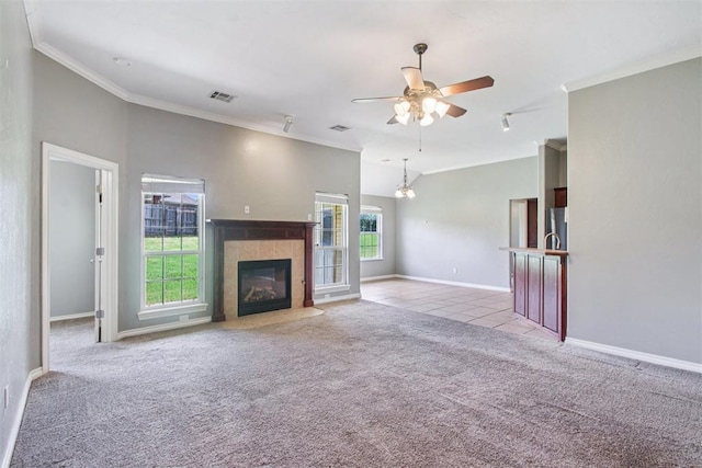 4605 Mackenzie Dr, Moore, OK 73160 - unfurnished living room with carpet flooring, ceiling fan, vaulted ceiling, a tiled fireplace, and ornamental molding