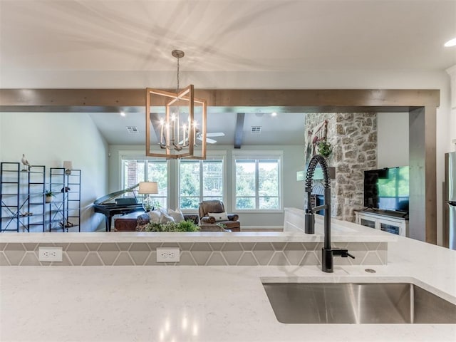 3508 Pavilion Pl, Edmond, OK 73034 - kitchen with open floor plan, a chandelier, decorative light fixtures, and light stone counters