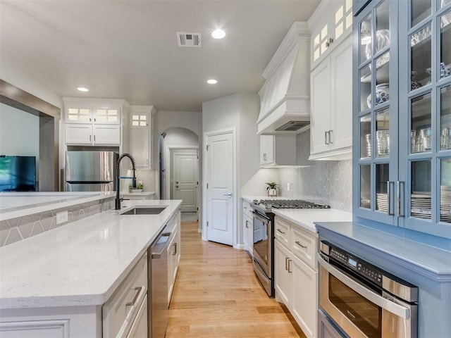 3508 Pavilion Pl, Edmond, OK 73034 - kitchen with stainless steel appliances, light wood finished floors, tasteful backsplash, recessed lighting, and arched walkways