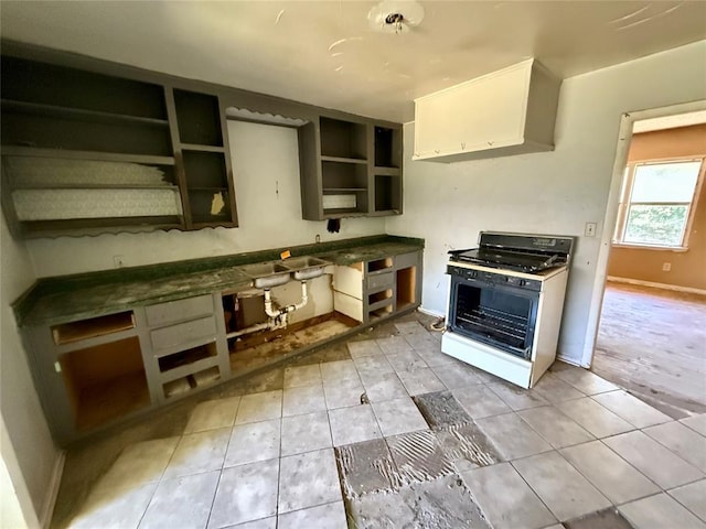 2918 N Prospect Ave, Oklahoma City, OK 73111 - kitchen featuring gas range oven, open shelves, light tile patterned flooring, and white cabinets