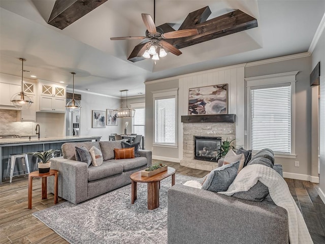 4821 Hidalgo Ave, Mustang, OK 73064 - living area with a stone fireplace, dark wood-style floors, ornamental molding, a ceiling fan, and recessed lighting