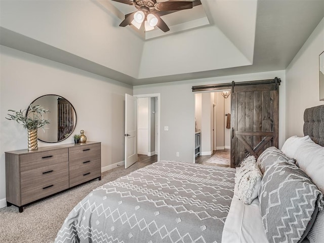 4821 Hidalgo Ave, Mustang, OK 73064 - bedroom featuring a barn door, a tray ceiling, light colored carpet, ensuite bath, and a ceiling fan
