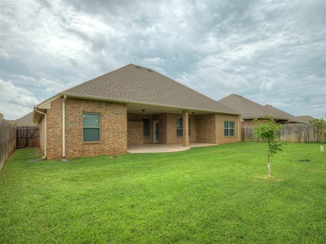 4821 Hidalgo Ave, Mustang, OK 73064 - back of property featuring a shingled roof, a fenced backyard, a patio, and brick siding