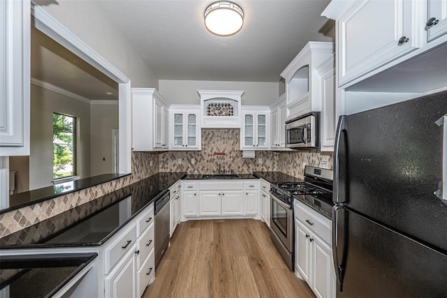 2916 Wood Thrush Way, Edmond, OK 73012 - kitchen with appliances with stainless steel finishes, glass insert cabinets, white cabinetry, light wood finished floors, and tasteful backsplash