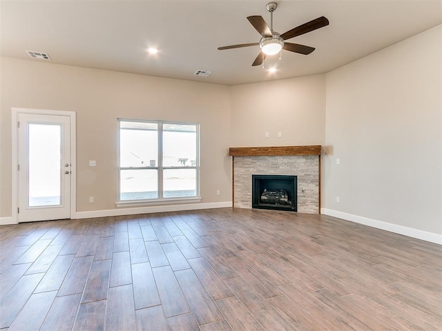 9313 NW 141st St, Yukon, OK 73099 - unfurnished living room featuring ceiling fan, wood finished floors, a stone fireplace, and recessed lighting