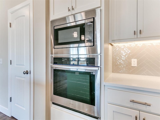 9313 NW 141st St, Yukon, OK 73099 - kitchen with appliances with stainless steel finishes, light countertops, white cabinetry, and tasteful backsplash