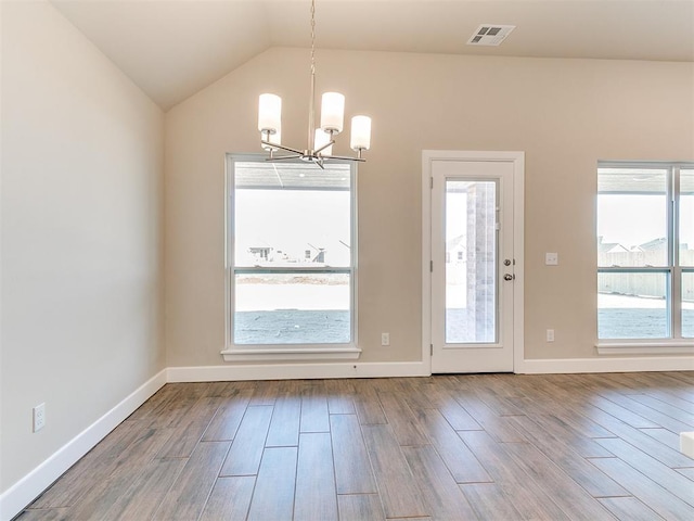 9313 NW 141st St, Yukon, OK 73099 - unfurnished dining area featuring a chandelier, wood finished floors, and vaulted ceiling