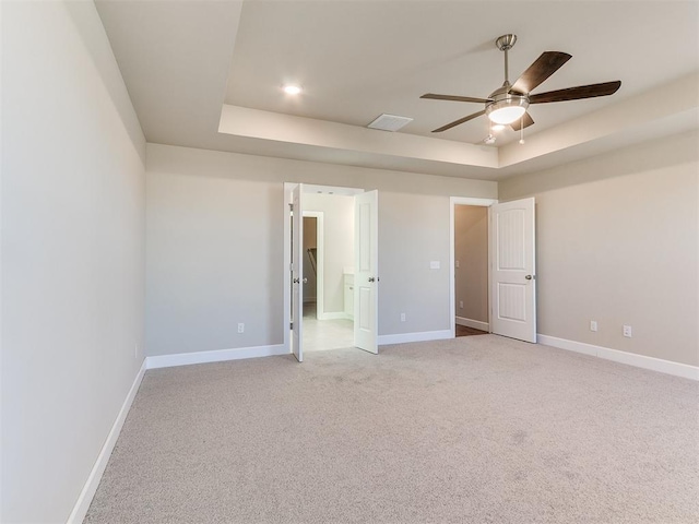9313 NW 141st St, Yukon, OK 73099 - unfurnished bedroom with a raised ceiling, light colored carpet, and ceiling fan