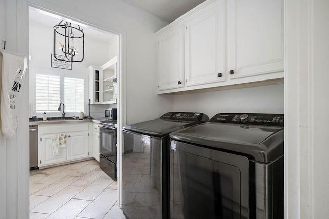 13848 Twin Ridge Dr, Edmond, OK 73034 - washroom with washer and clothes dryer, cabinet space, a chandelier, and light tile patterned floors