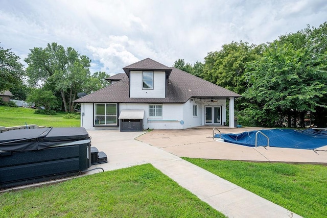 13848 Twin Ridge Dr, Edmond, OK 73034 - back of house featuring a hot tub, a patio area, a yard, a ceiling fan, and a covered pool