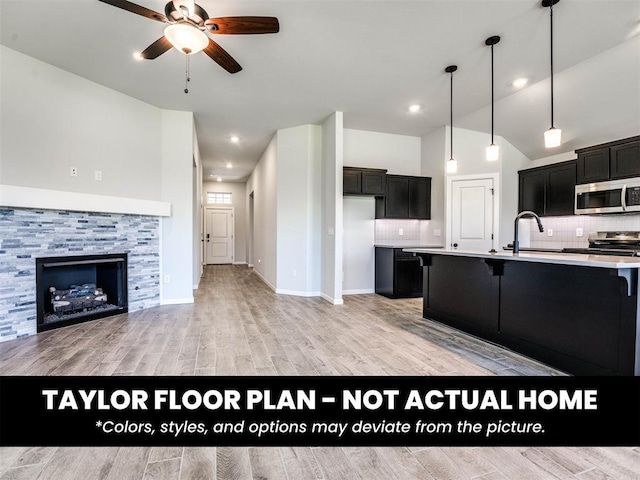 2508 Marsh Ln, Midwest City, OK 73130 - kitchen with stainless steel microwave, ceiling fan, dark cabinets, decorative backsplash, and light wood-type flooring