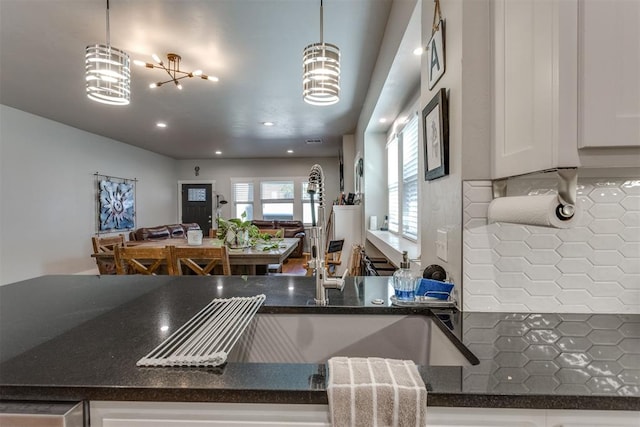 3424 NW 16th St, Oklahoma City, OK 73107 - kitchen with white cabinetry, dark stone countertops, pendant lighting, recessed lighting, and open floor plan