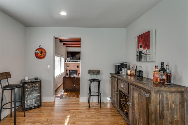 3424 NW 16th St, Oklahoma City, OK 73107 - indoor dry bar featuring beverage cooler, light wood-type flooring, a brick fireplace, and recessed lighting