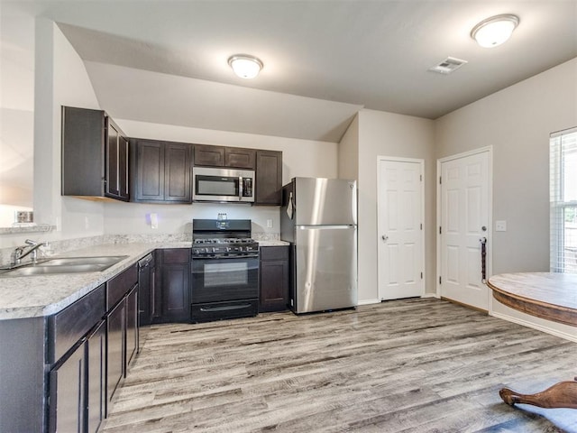 10408 NW 17th St, Oklahoma City, OK 73127 - kitchen featuring appliances with stainless steel finishes, light wood-type flooring, light countertops, and dark brown cabinets