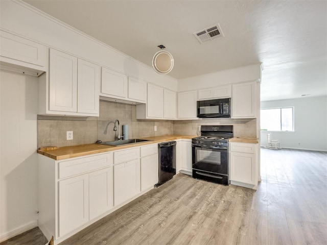 6908 NW 36th St, Bethany, OK 73008 - kitchen with black appliances, tasteful backsplash, white cabinets, and light wood-style flooring