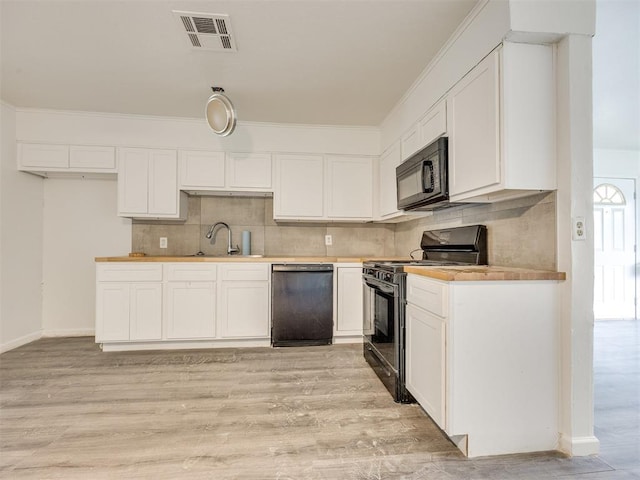 6908 NW 36th St, Bethany, OK 73008 - kitchen featuring black appliances, backsplash, white cabinets, light wood-style flooring, and light countertops