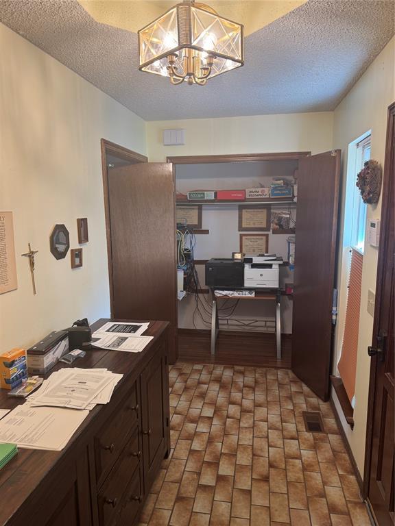 11700 Sierra Rd, Oklahoma City, OK 73162 - kitchen featuring a desk, a textured ceiling, a chandelier, brick patterned flooring, and dark countertops