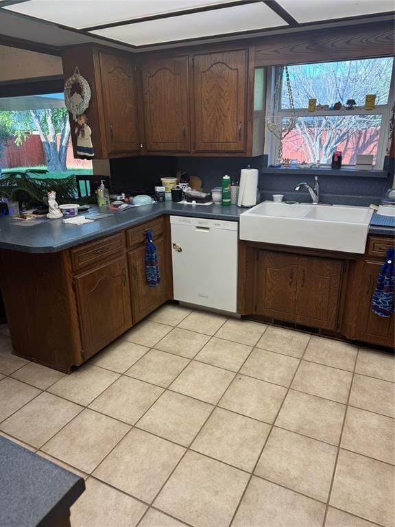 11700 Sierra Rd, Oklahoma City, OK 73162 - kitchen featuring white dishwasher, dark countertops, and light tile patterned flooring