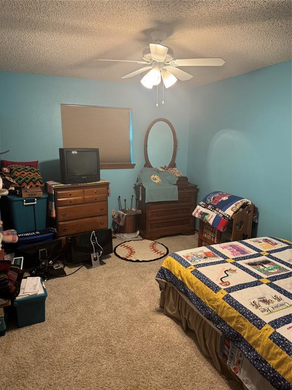 11700 Sierra Rd, Oklahoma City, OK 73162 - carpeted bedroom with a ceiling fan and a textured ceiling