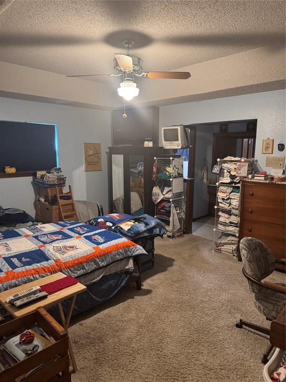 11700 Sierra Rd, Oklahoma City, OK 73162 - carpeted bedroom featuring a textured ceiling and ceiling fan