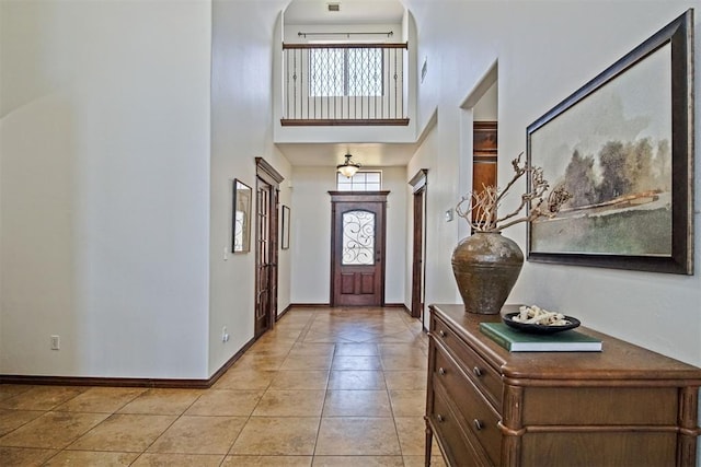 917 Erinova Dr, Yukon, OK 73099 - foyer with a high ceiling, plenty of natural light, light tile patterned flooring, and arched walkways